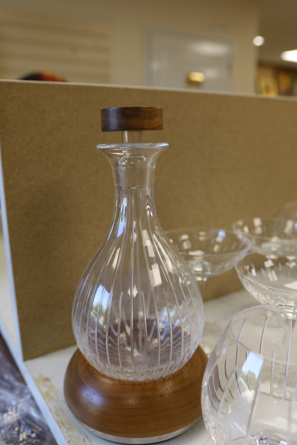 A Linley Glyndebourne pattern cut glass decanter with a silver mounted stopper, on a weighted wooden coaster stand, and a matching set of ten goblets, and eight champagne coupes, largest 30cm high. Condition - all in ver